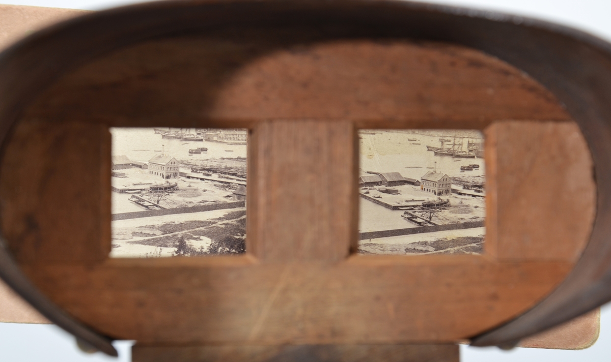 Et stereoskop tilvirket i mørkt ubehandlet treverk med et fint dreid sammenleggbart håndtak festet til brillen med et messingledd. Det ovale tittekammeret er utført i finer. Både rammen til å feste stereofotografiene og begge linsene mangler. 
24 stereofotografier eller stereokort fra ulike produsenter antagelig produsert på slutten av 1800-tallet hører til stereoskopet.