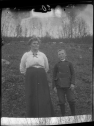 Portrett av en kvinne og en gutt, fotografert stående utendø