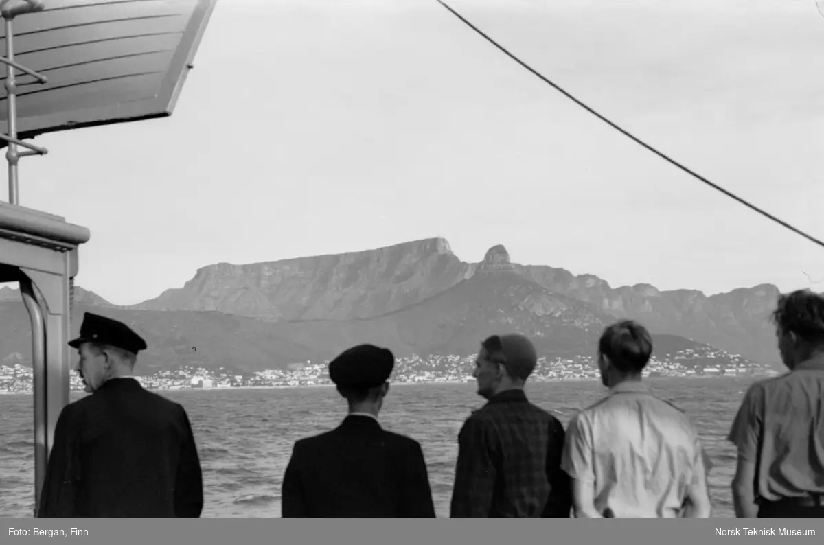 Fem personer på skip, bakfra, ser mot innseiling til Cape Town