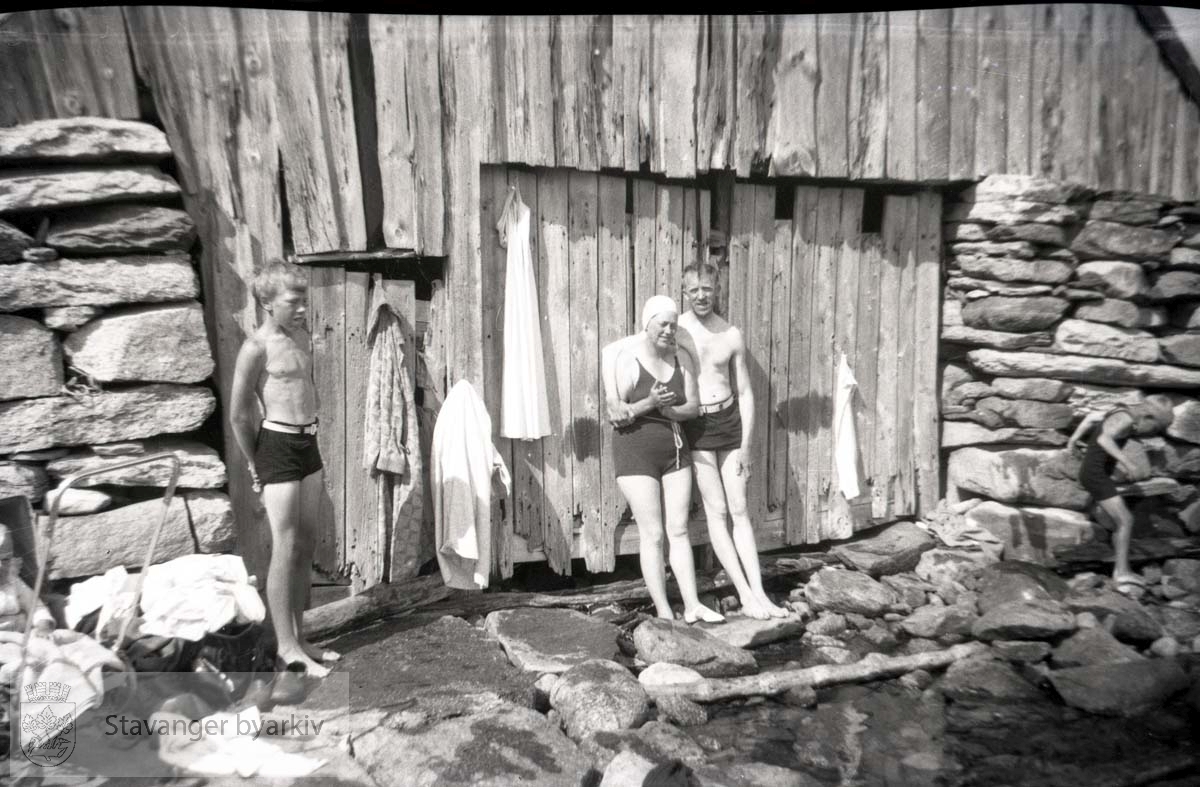 Familien Iversen bader ved naust. Oscar Iversen til høyre.