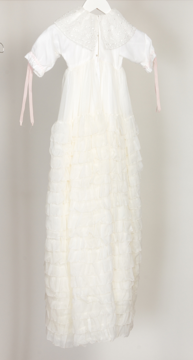 Dåpskjole med bred blondekrage i halsen og rosa silkebånd ved hvert håndledd og i front