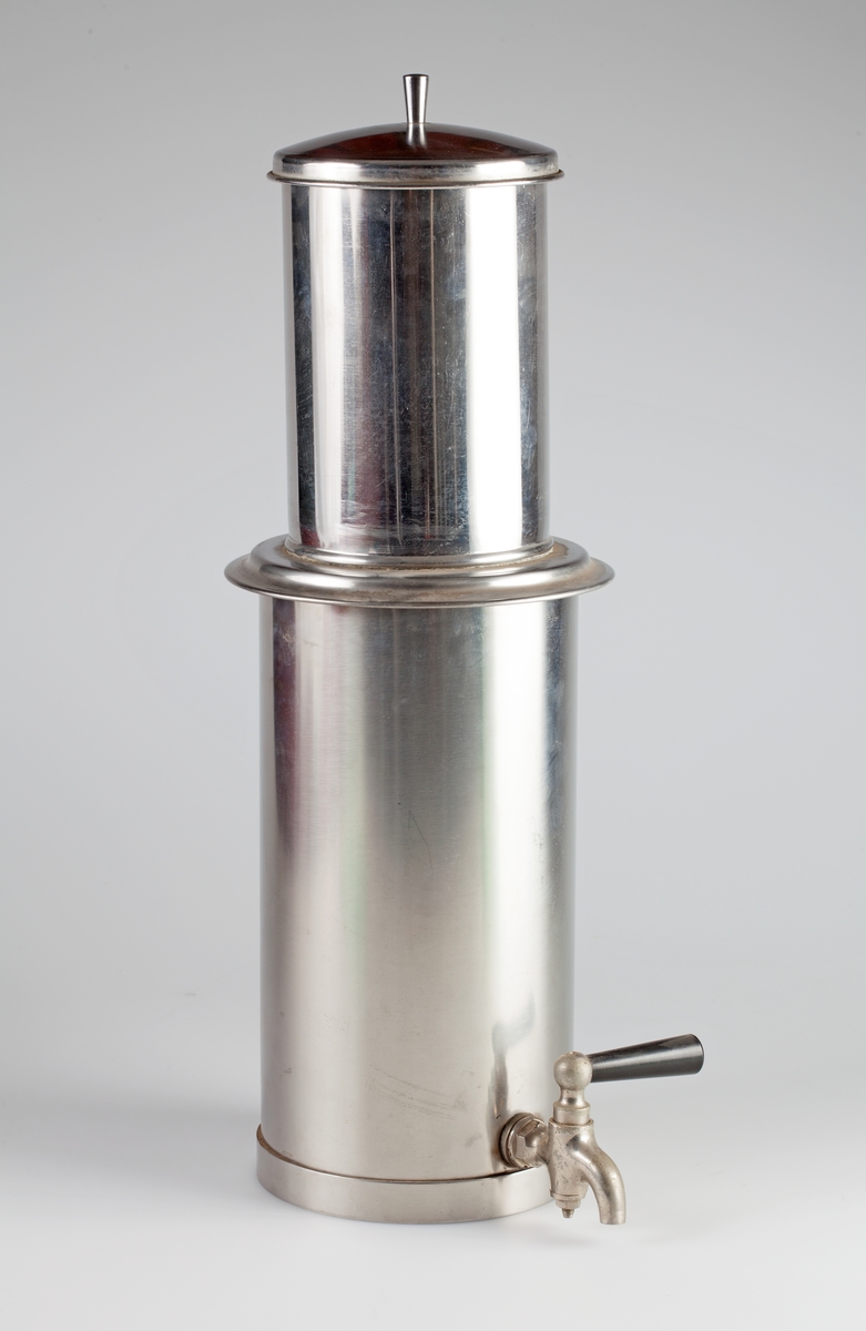 Filterpresse i rustfritt stål. Består av fire deler: Sylinder med tappekran (A). konisk filter (B), lokk (C) og stempel (D).