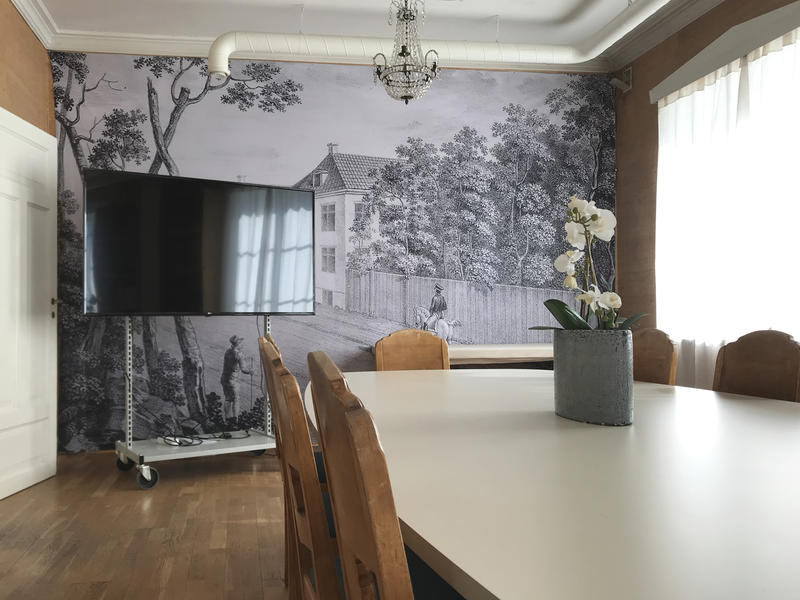 Bilde fra stua i Konservatorboligen ved Eidsvoll 1814, viser et møtebord og en stor skjerm.