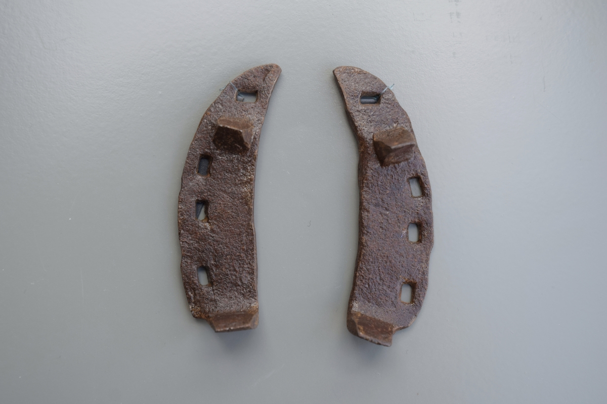 Oksesko - ett par halvdeler. Av jern, smidd og essesveisa av 5 mm flattjern, med fire sømhull, hake og grev