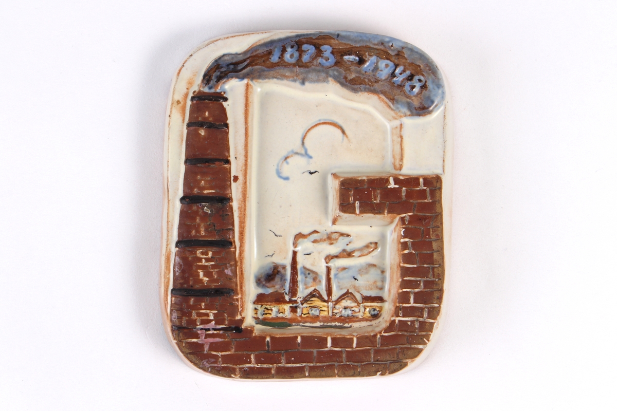 Askebeger med kant som er utformet som bokstaven G og dekorert med relieff som viser fabrikkpipe med røyk.