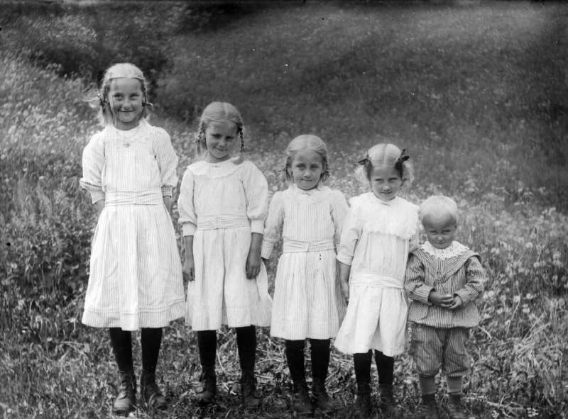 Gruppe, fem barn, fire i lyse kjoler.