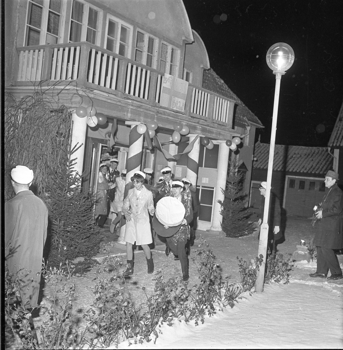 Studenter vid Grännaskolan, 1967, springer ut från Borgmästargården. Det är snö på marken.