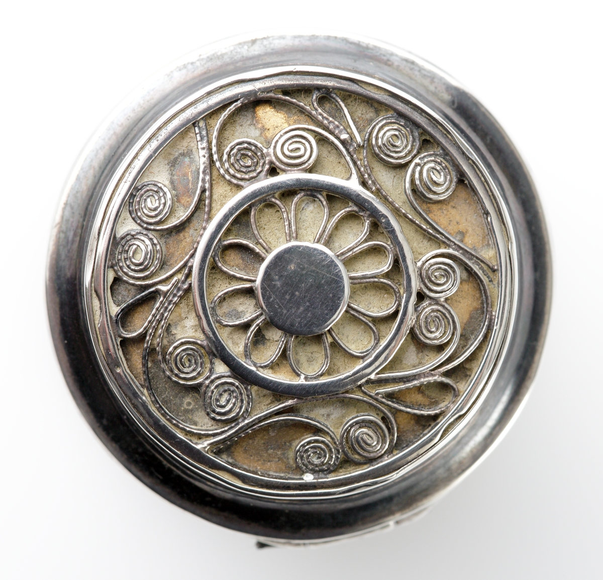 Luktdosa av silver.
Cylindrisk modell med filigranmönster (blomma m.m.) på locket. Invändigt förgylld.
Stämplar på dosans undersida.