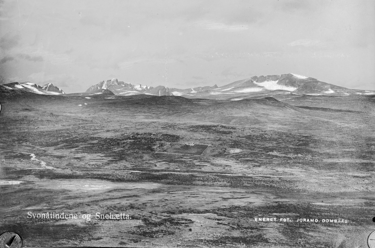 Oversiktsbilde mot Snøhetta og Svånåtind til venstre. Påskrift: Svonåtindene og Snehætta