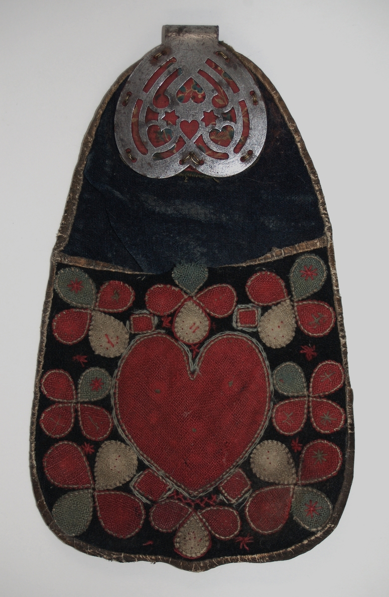 Väska, av skinn och tyg med applikationer. Spänne av metall med genombrutet mönster, märkt 1836. Skinn på bakdisdan av väskan.