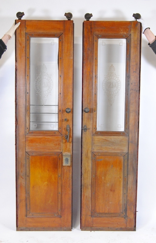 Ett par skjutdörrar med glasfönster. Båda dörrarna har "HdSJ" etsat i glaset samt dekorationer runt om. Den ena sidan av dörrarna är målad i vinrött och den andra har lackat trä. I toppen av dörrarna sitter två hjul. Den ena dörren (:1, vänster från utsidan) har knoppar på bägge sidor samt en ögla för låsning av handtaget och textilklädda sidor. Gallret framför glaset saknas. Den andra dörren (:2) har knoppar och handtag på båda sidor, ett galler som skydd framför nederdelen av fönsterrutan på den bemålade sidan och en askkopp nedanför handtaget på den lackade sidan. 

Obs! Måtten gäller den :2. :1 är något smalare pga. att den inte har en av listerna eller askkopp.