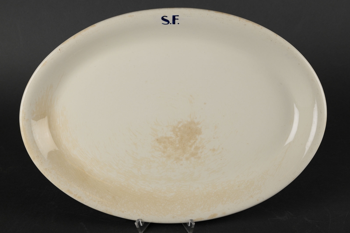 Hvitt ovalt fat med påskriften "S.F."