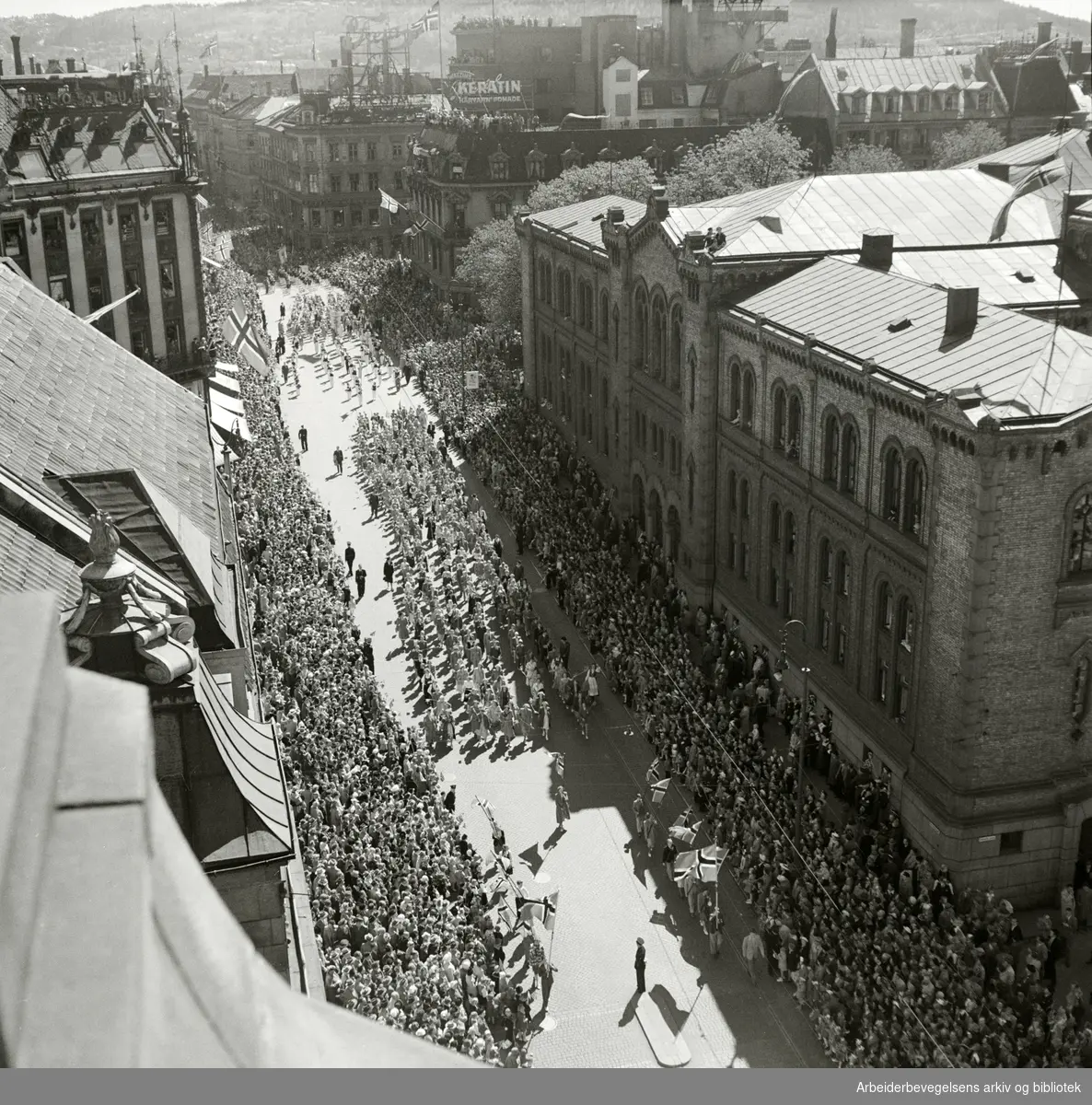 Barnetoget passerer Stortinget, 17. mai 1951. Fotografert fra taket på Grand Hotel.