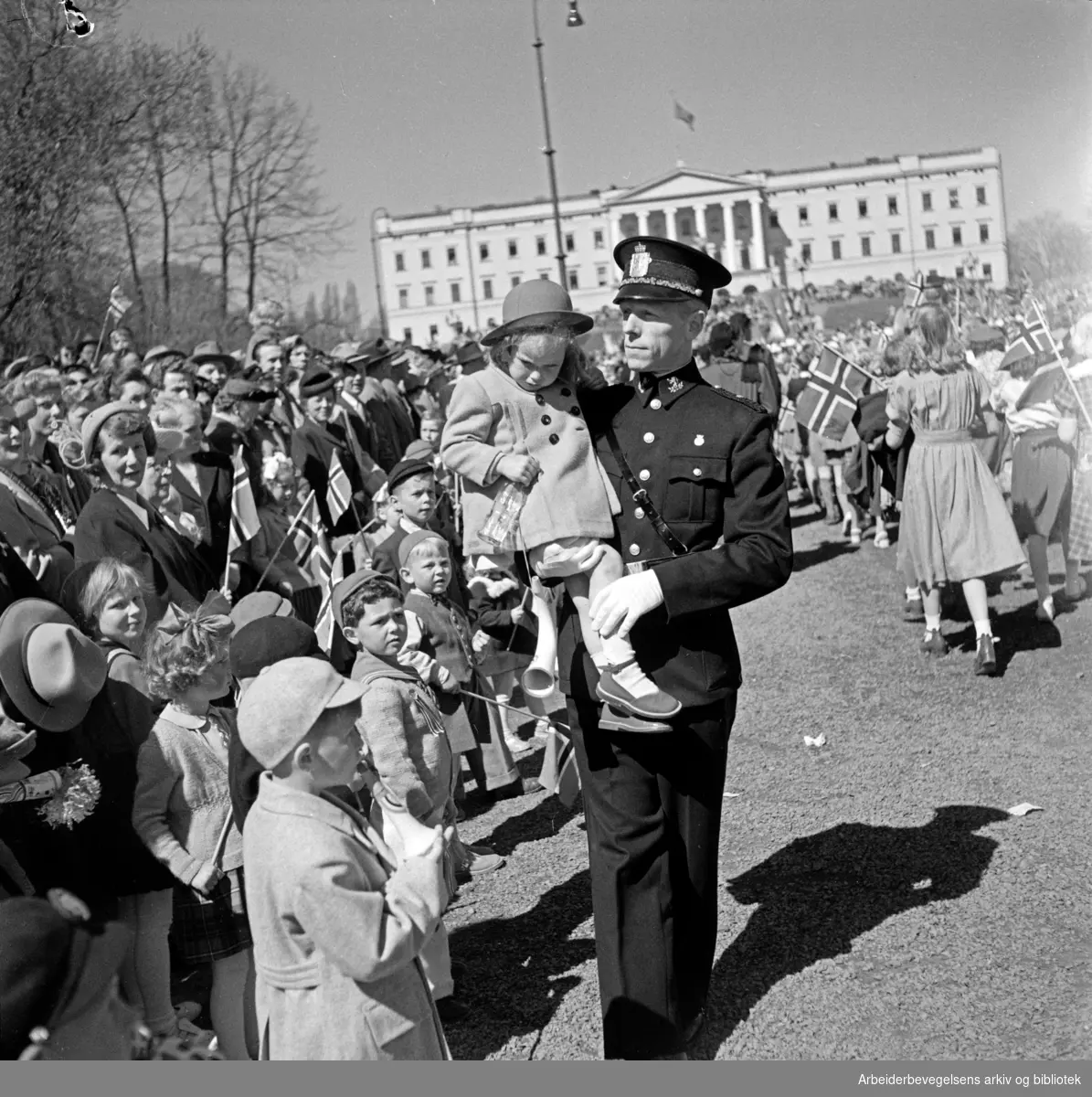 Politikonstabel tar vare på bortkomment barn. 17. mai 1951. Trist. Slottet.