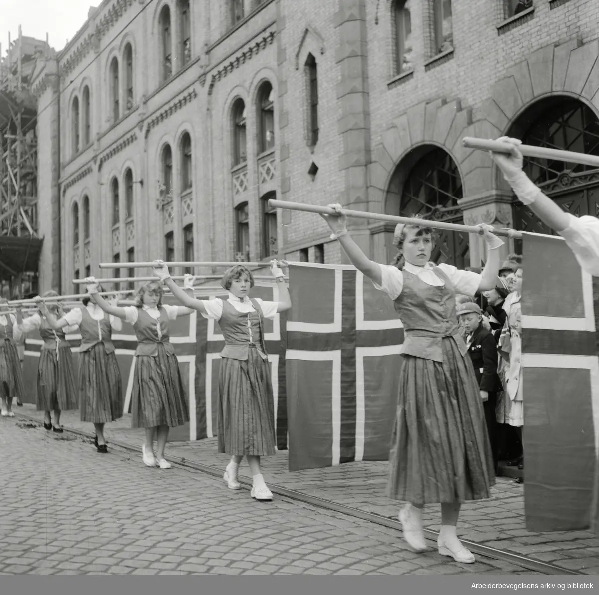 Barnetoget passerer Stortinget 17. mai 1955. Flaggborg.