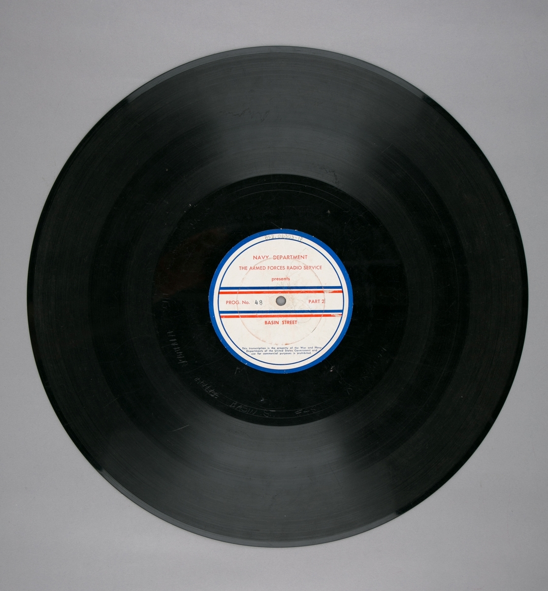 Grammofonplatesamling. LP-plate med tittel "The Armed Forces Radio Service" utgitt av Navy Department. Plate i svart vinyl spilles på platespiller med 33 1/3 omdreininger i minuttet (33-plate).