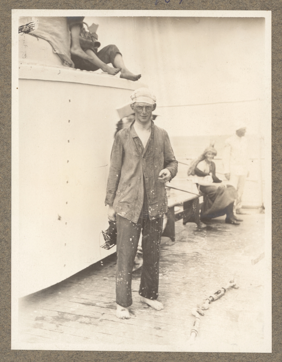 Bilden föreställer en sjöman efter linjedopet ombord på Fylgia. Han är barfotat och röker en cigarr. I bakgrunden vilar en princessa.
