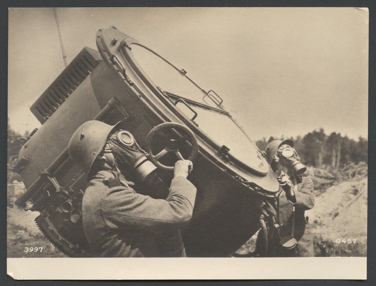 Bilden visar två soldater som arbetar med en stor strålkastare. Båda bär gasmasker.