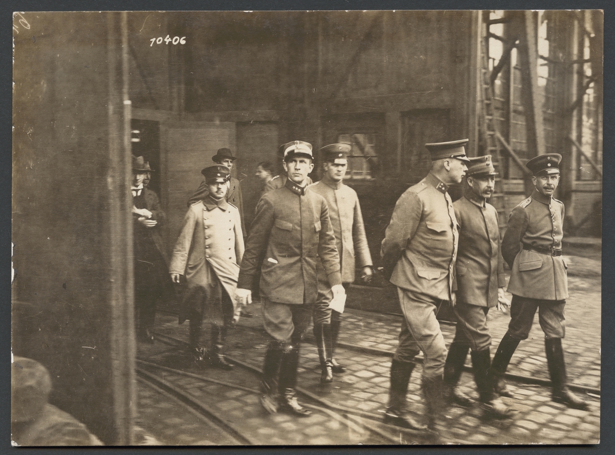 Bilden visar en grupp militärer på väg genom ett industriområde.