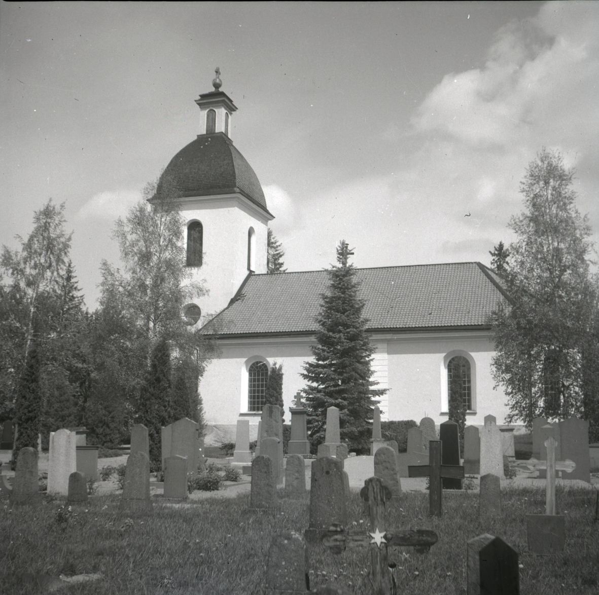 Blackstads kyrka med kyrkogården och gravvårdar.