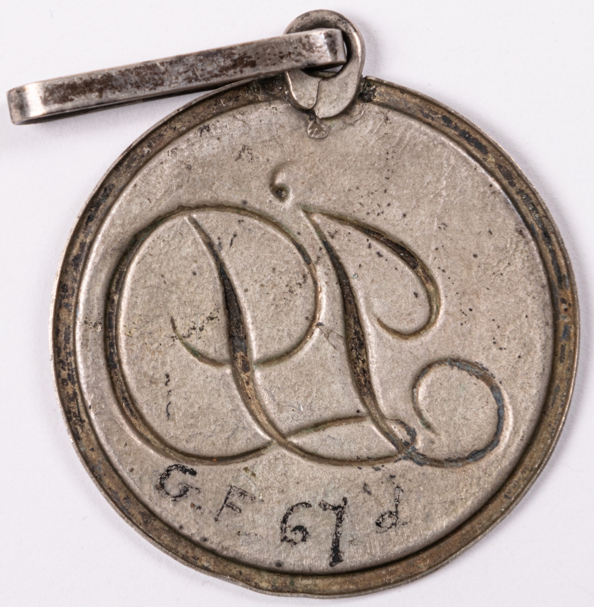Emblem för föreningen Idka Dygden. Rund form med hänge.
Del av 6 stycken föreningestecken i silver, två korsformiga, 4 runda.