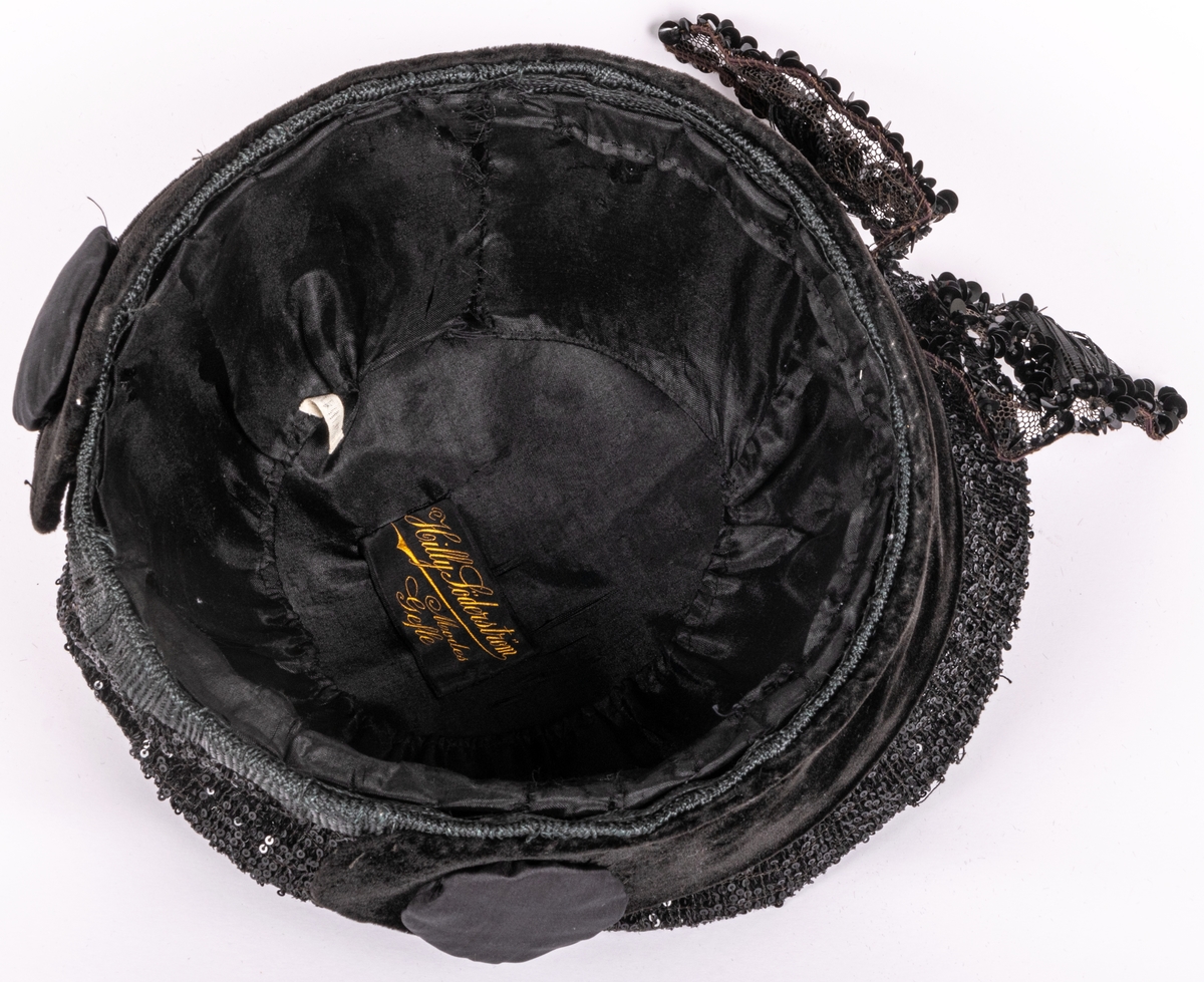 Hatt utan brätten, rikligt dekorerad med strå och paljetter.
Etikett: Hilly Söderström Modes Gefle.