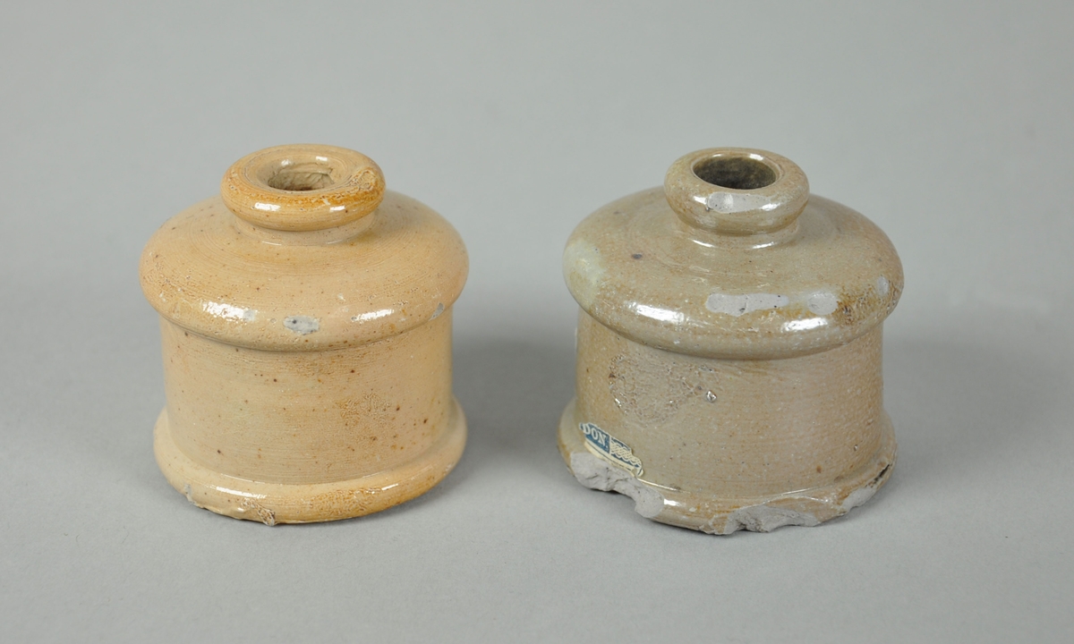 To blekkhus av keramikk. Etiketten er delvis forsvunnet på det ene og helt falt av på det andre.