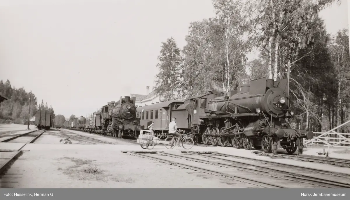 Rena stasjon med damplokomotiv type 26c nr. 436 med godstog til Hamar, tog 5292  i spor 2 og damplokomotiv 26b 230 med dagtoget fra Trondheim til Oslo Ø over Røros, tog 302, i spor 1