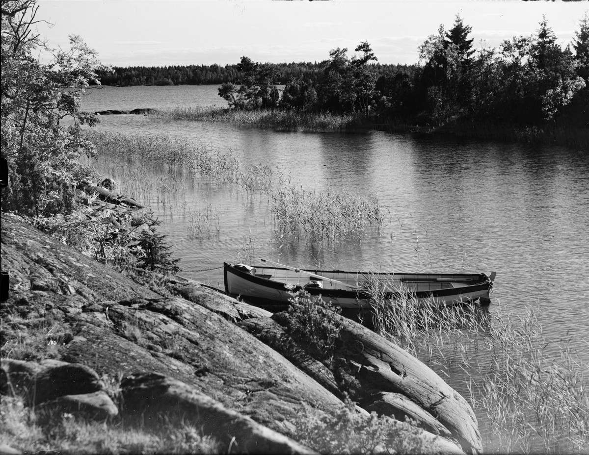 Skärgårdsvy - roddbåt ligger förtöjd vid klipporna, Östhammar, Uppland
