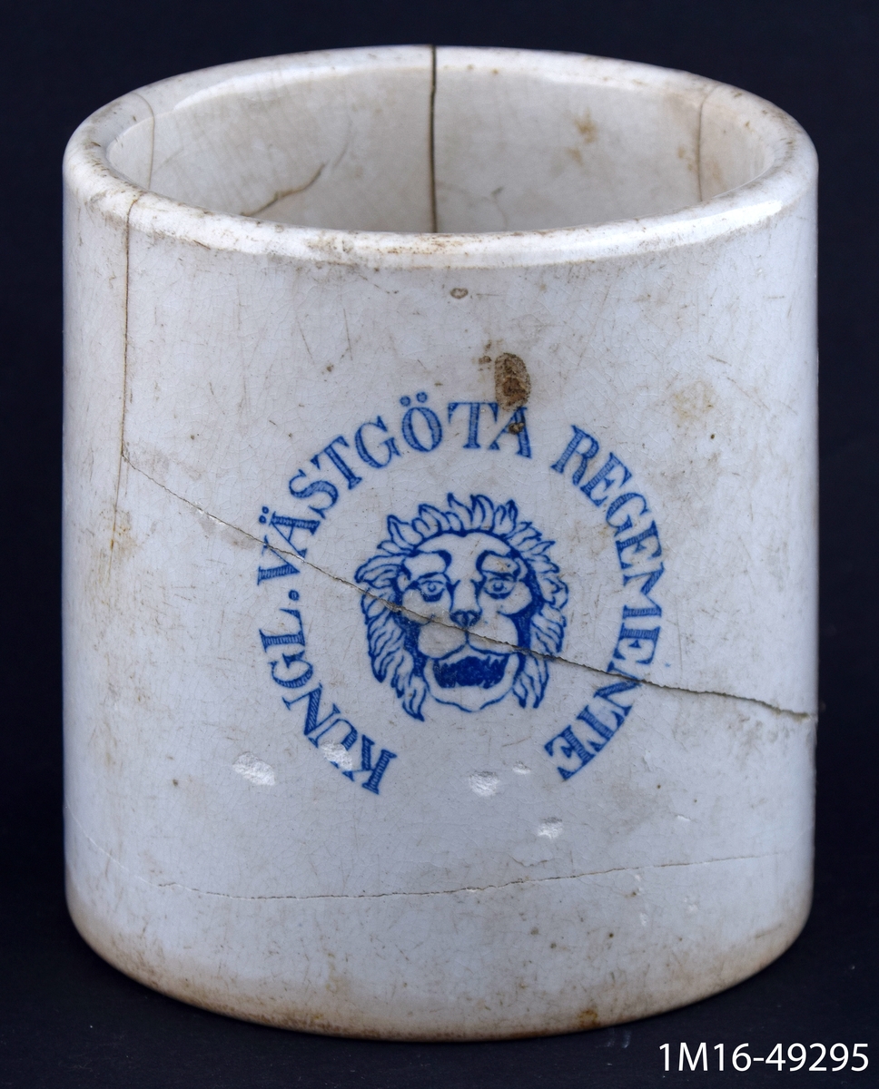 Mugg eller bägare, vit med ett lejonhuvud i och texten: Kungl. Västgöta regemente i blått tryck. Tillverkare: Rörstrand.