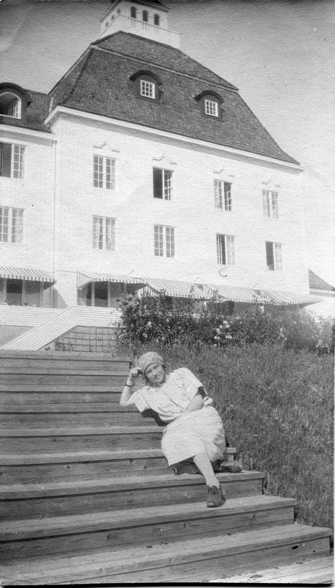 Kvinne i trappen foran en stor bygning