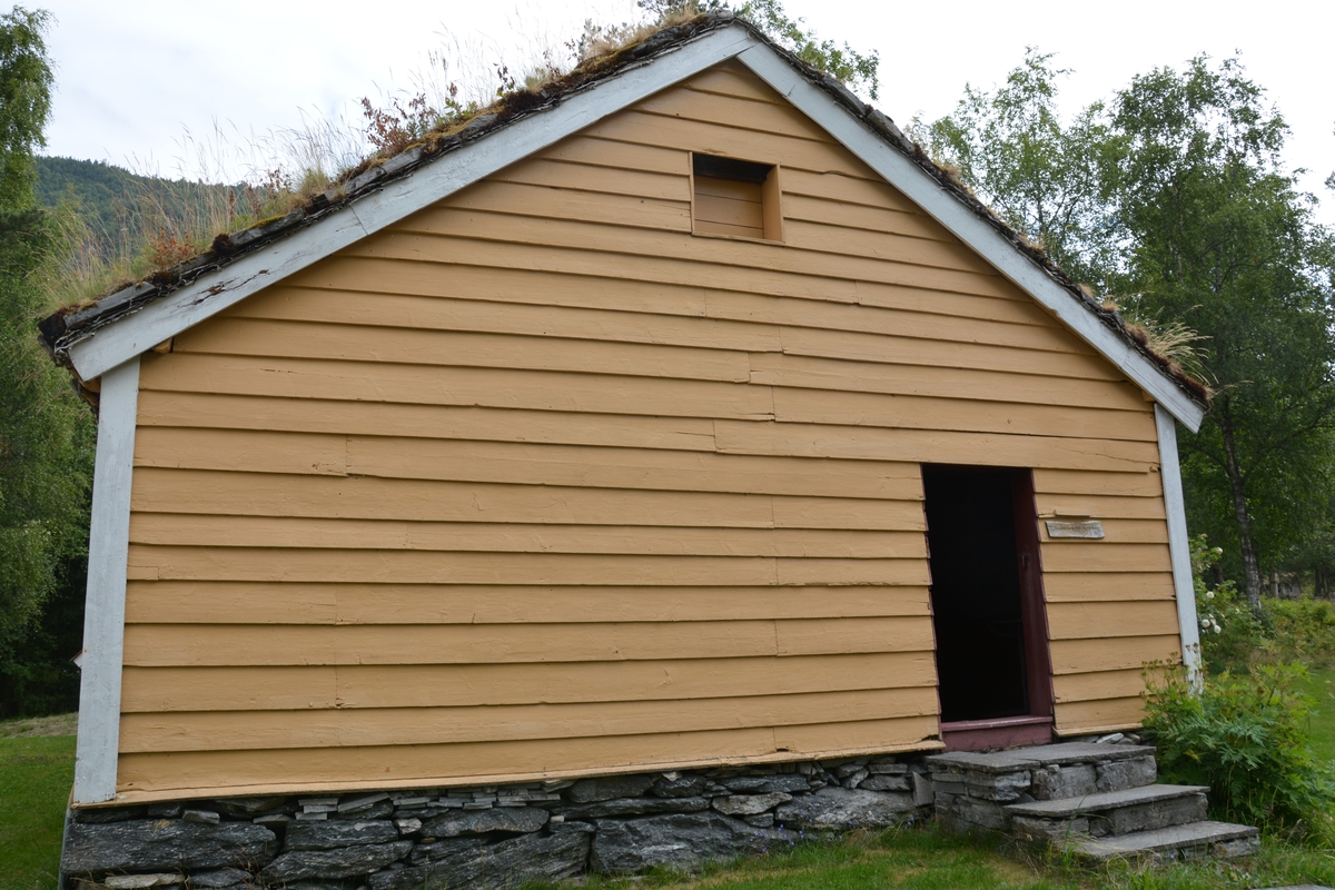 Tømra bygning med treromsplan: forstove/"Døra", skulestova og kammes. Jarnomn. Liggande panel. Torvtak.