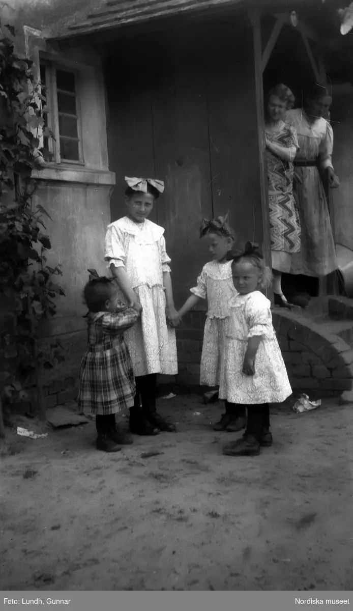 Motiv: Utlandet, Spreewald 92 - 101 ;
Kvinnor i folkdräkt fotograferade bakifrån, landskapsvy med vatten och träd, porträtt av fyra flickor som håller händer och två kvinnor som står på trappan till ett hus.