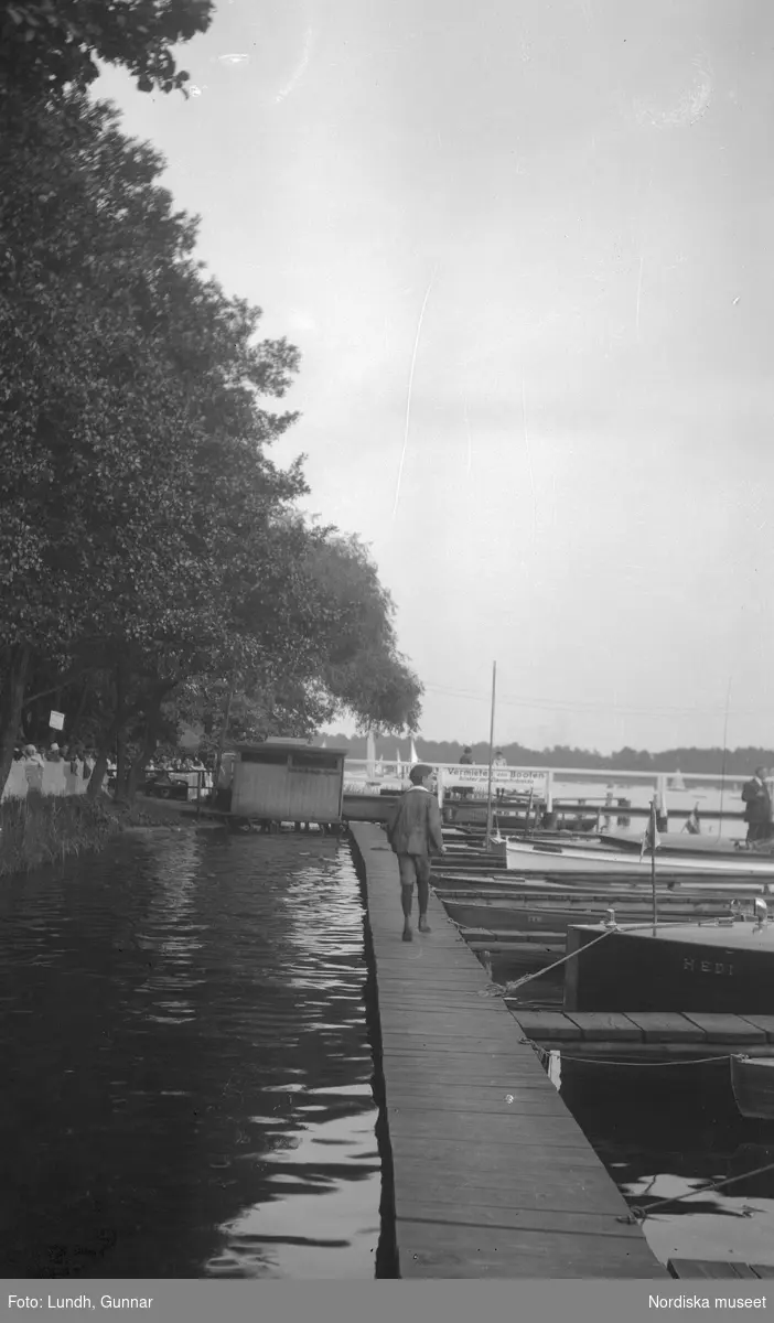 Motiv: Utlandet, Berlins Omgivningar 157 - 177 ;
Landskapsvy med förtöjda båtar på en sjö, en hamn med båtar, anteckning på kontaktkarta 172 "detalj av båt på Wannsee".
