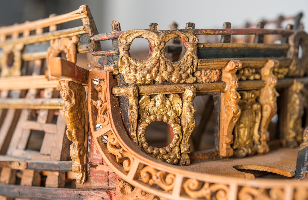 This unplanked model of a three-decker can be dated to c. 1660 and is one of the world's oldest models of a warship. Although not definitively identified, recent research links it to the Swedish ship *Riksäpplet*, designed by the English master shipwright Francis Sheldon and launched in 1661.     
The model was possibly made for Sheldon, who came to Sweden in 1659. He was one of a number of English shipwrights employed by the Swedish crown during the period. Previously, most Swedish warships had been built in the Dutch style.

From around 1660, the English Royal Navy’s administrators commissioned models that were accurately detailed and true to scale. These miniatures, which came to be called Navy or Admiralty Board models, had an unplanked lower hull to emphasise the shape of the underwater body. 

The model was restored by rear-admiral Jacob Hägg in the late 1890s. Missing parts have been reconstructed using lighter coloured wood.

3D model produced by Adam de Kaminski and Vasilis Haroupas for SMTM, 2023
