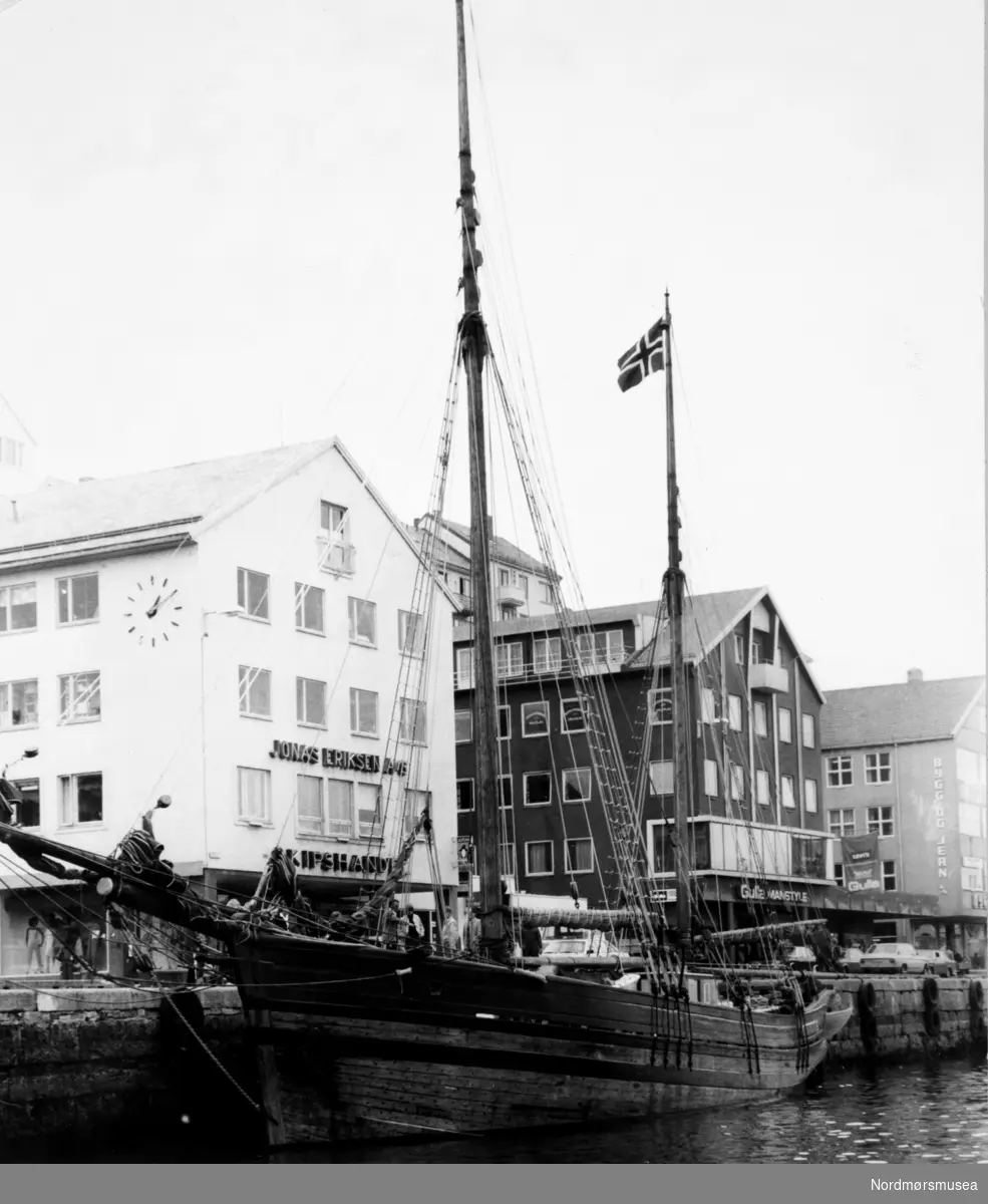 "Anna Christine" (seilskute) foran Jonas Eriksen skipshandel i Vågeveien 4.  Bildet er fra avisa Tidens Krav sitt arkiv i tidsrommet 1970-1994. Nå i Nordmøre museums fotosamling.