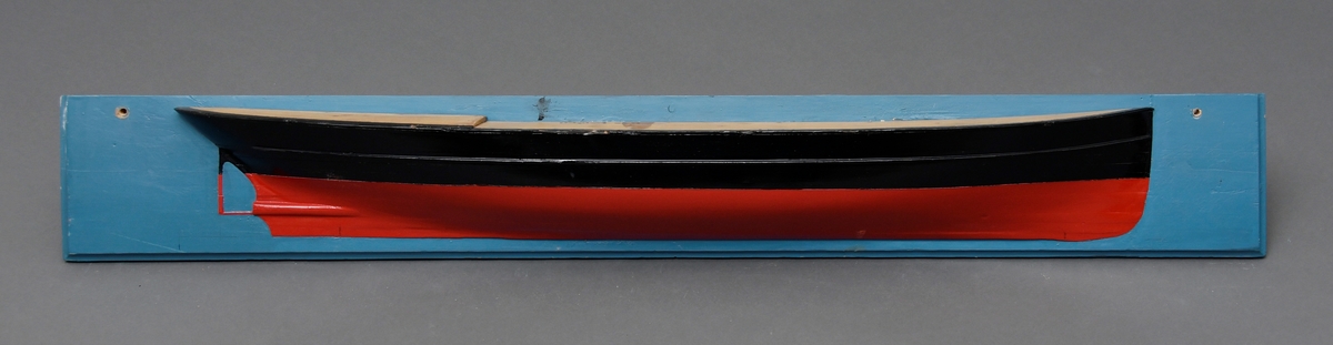 Halvmodell av DS "Helgeland" festet på en blåmalt treplate. To gjennomgående skruehull for veggmontering. Modellen er laget av tre, og er malt i sort og rødt.