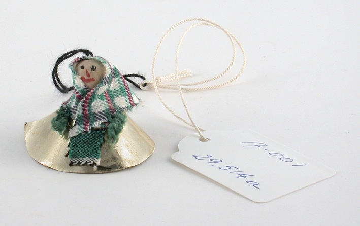 Figur av grön piprensare med huvud av trä. Kjol i metallpapper och schalett i tyg.
:1 Guldfärgad. 
:2 Blågrön. 
:1-2 Tråd för upphängning.