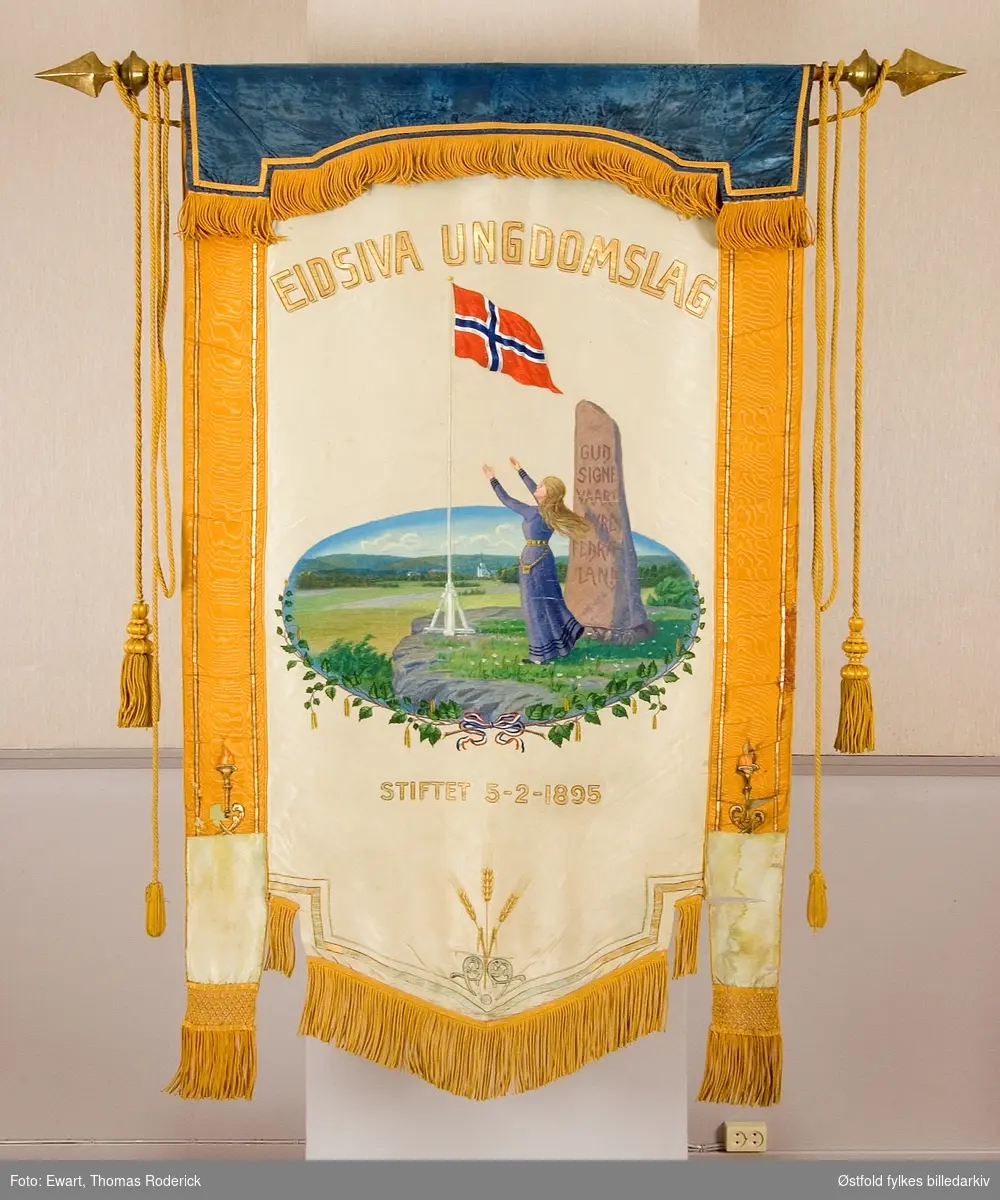 Fane til Eidsiva Ungdomslag stiftet 3. februar 1895. Forside og bakside.
Påskrift på bauta i motiv:  Gud signe vaart dyre fedreland.