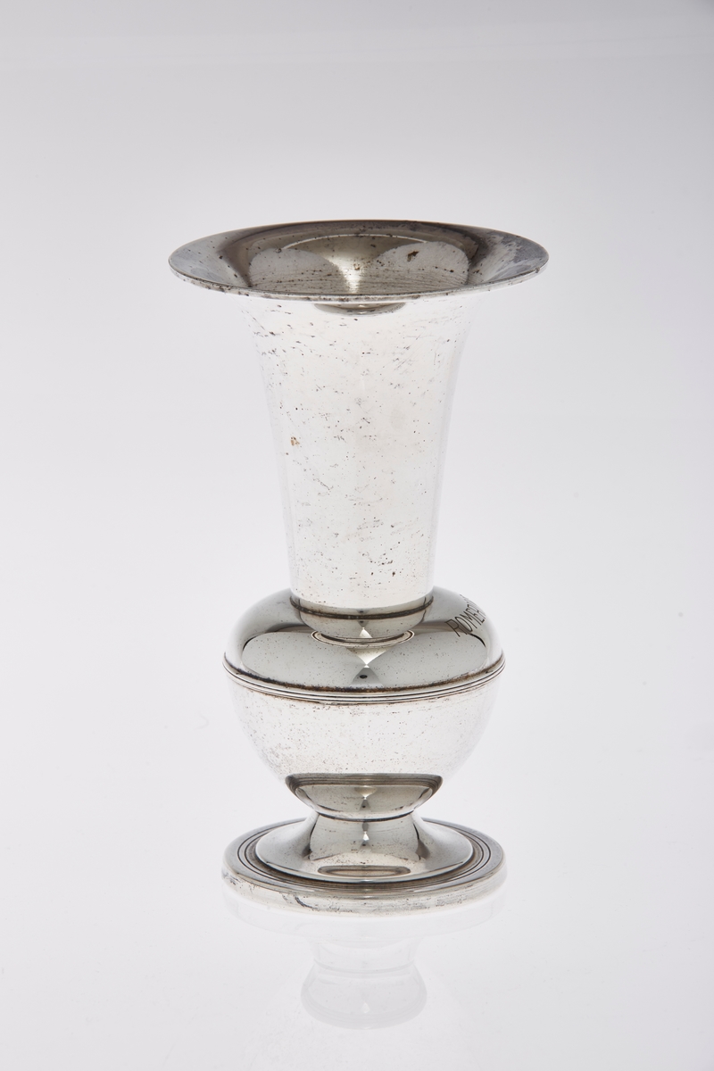Pokal formet som vase, med stett i sølvplett. Har inskripsjoner.