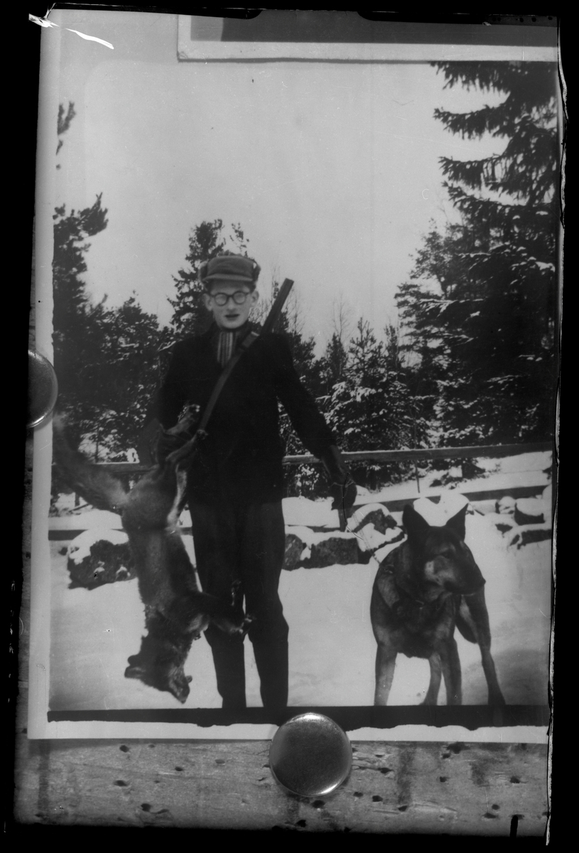 En jägare med jakthund och en skjuten räv