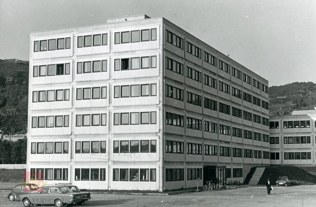 Vegkontoret i Nordland, bygning Nordstrandvegen 41. Bygningen ble tatt i bruk 1. desember 1975. Foran på parkeringsplassen står flere personbiler. Fremst en Volvo 142 Deluxe 1973 modell og bak VW Type 1 "Boble."