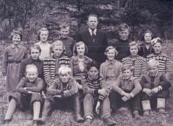 Elever og lærer på Sævland skole 1940. Poserer på gresset, t
