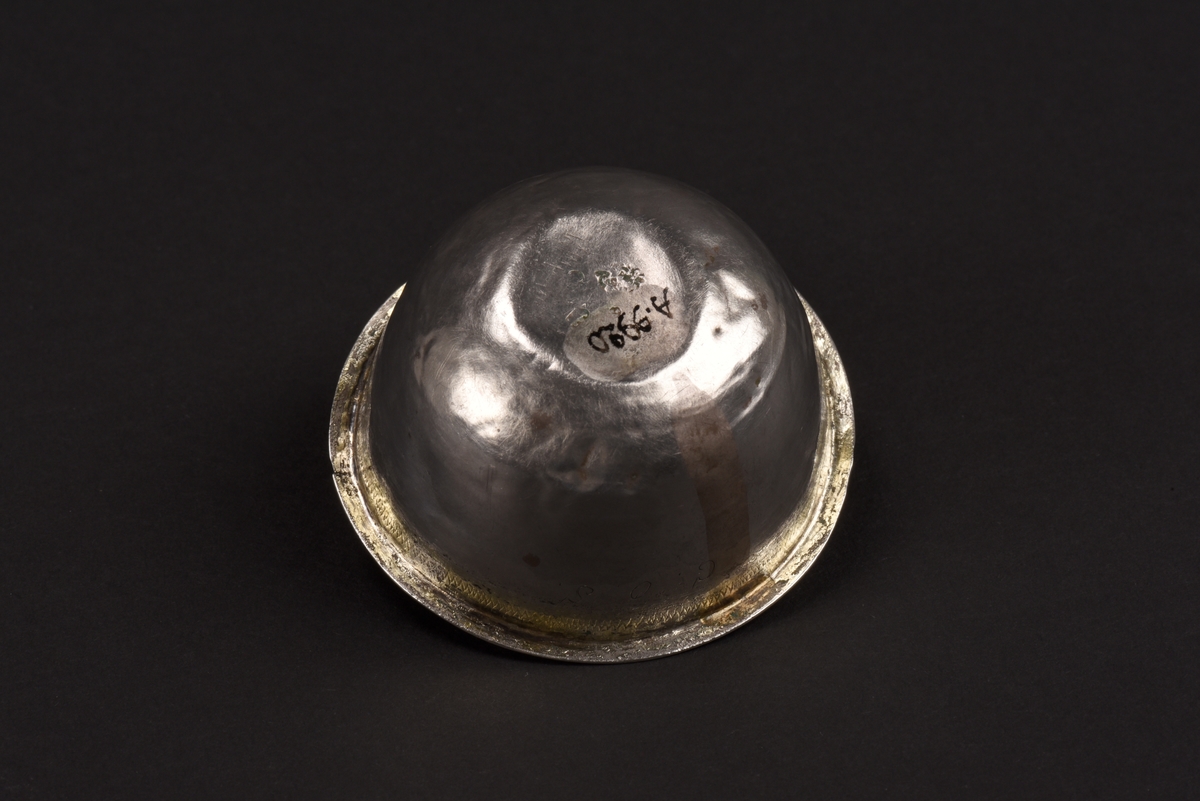 Rund supkopp av silver med liten utvikt kant vid mynningen. Under kanten en inristad sicksacklinje samt förgyllning. Även insidan är förgylld. På sidan initialerna COS. Under är koppen stämplad med Norrköpings stadsstämpel, årsstämpel C (1761) samt HN vilket står för silversmed Henrik Nourin.