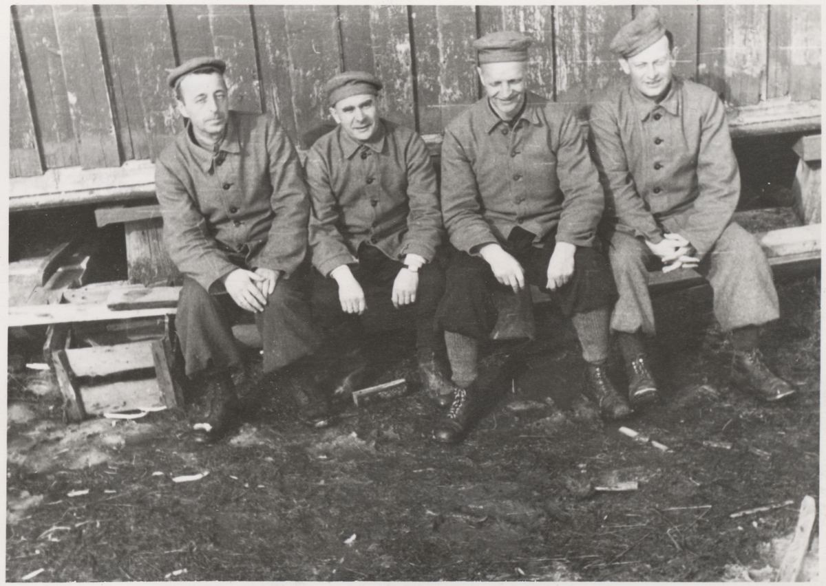 Gruppe av "Trondheimsgislene" på Falstad våren 1942. Fra venstre Gert Munthe, Erling Østerberg, Ole Espaas og Harald Halvorsen. Bildet er tatt på Falstad nedre, ved stabburet på vestsida av driftsbygningen.