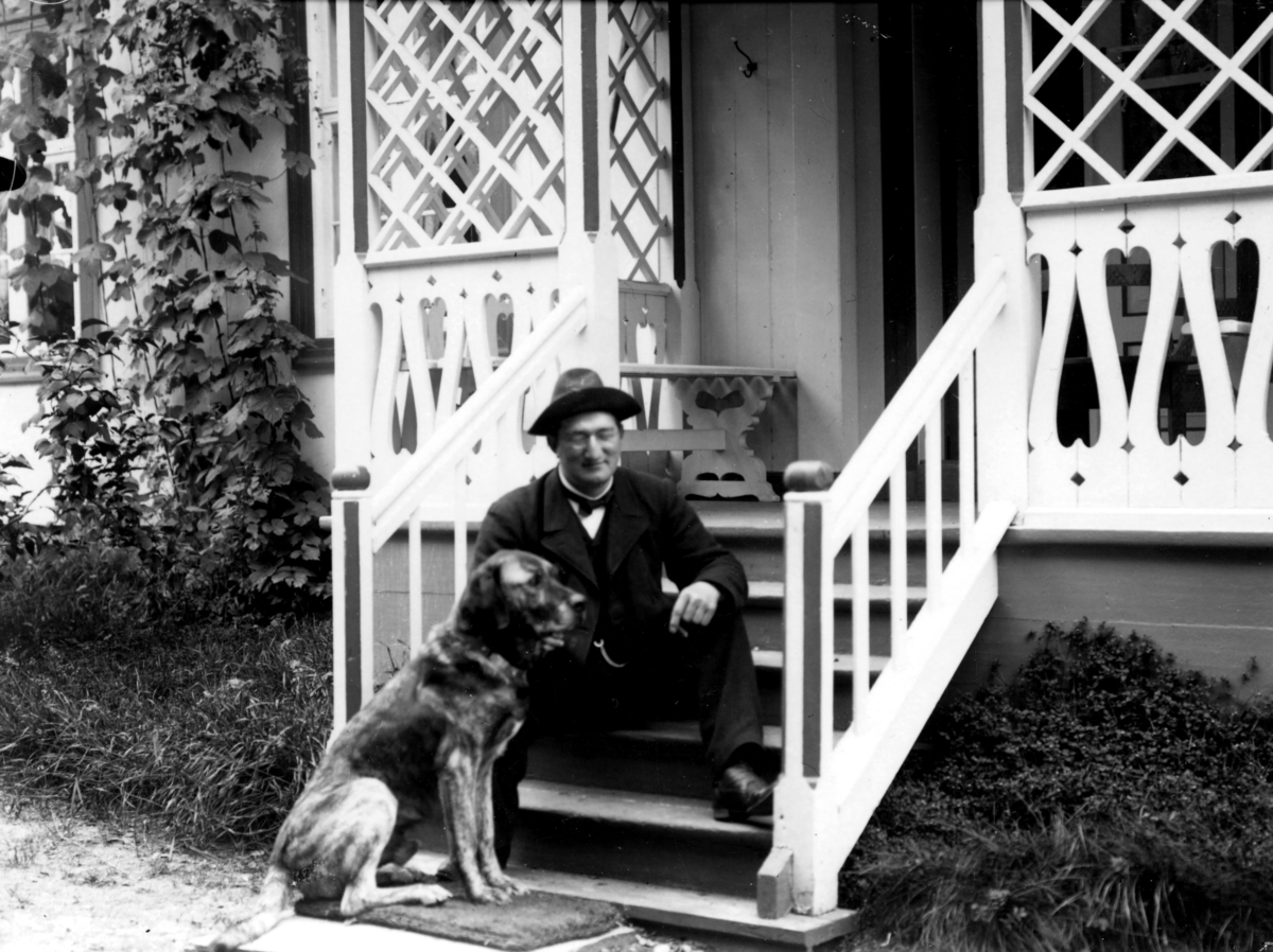 Doktor Otto Mejlænder sitter på trappa med hund.