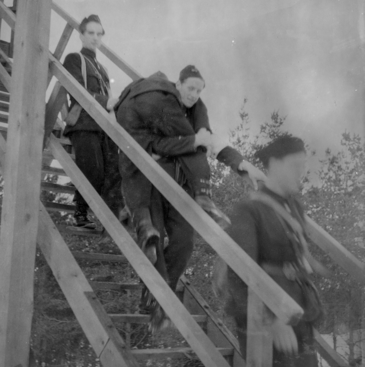 Skadad soldat bärs nedför trappan från ett luftvärnstorn vid sjukvårdsövning i fält vid F 11 Södermanlands flygflottilj, 1945. 

Ur fotoalbum "Sjukvårdsskolan 15/1-15/3 1945" från F 11.