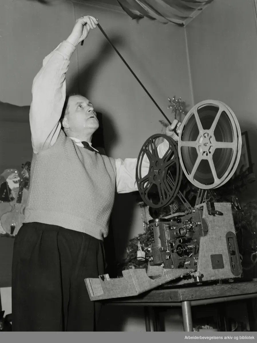 Reportasje fra Grønland brannstasjon, januar 1953. Brannmann Henry Bjørge gjør klar filmfremviseren.