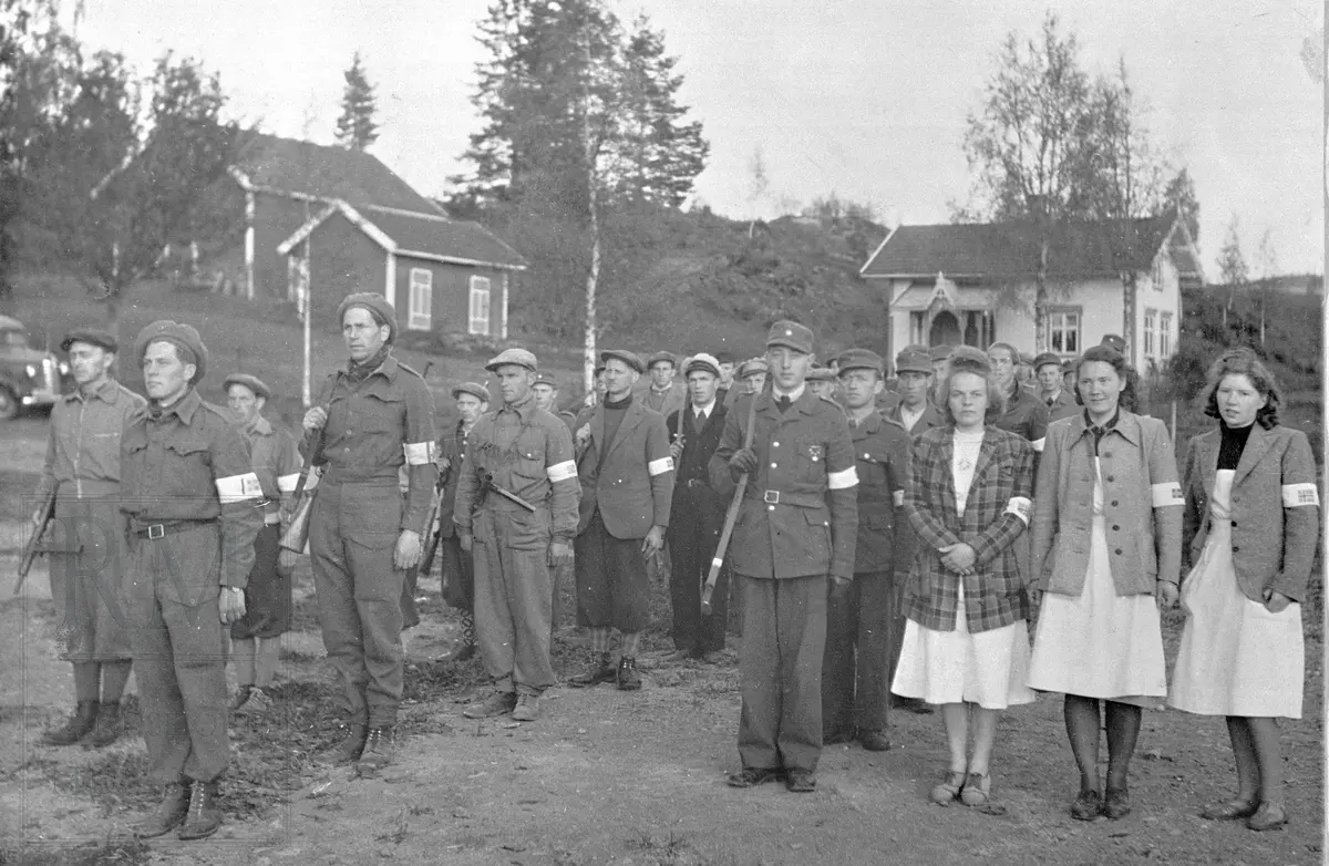 Hjemmestyrkene etter frigjøringen. Vaktsjef Josef Monserud med Milorg-troppen og kjøkkenjenter foran Folkets Hus.