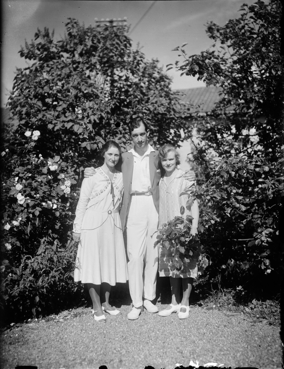 Sara, Josef och Tyra Edhlund vid fruktträd i trädgården, Östhammar, Uppland
